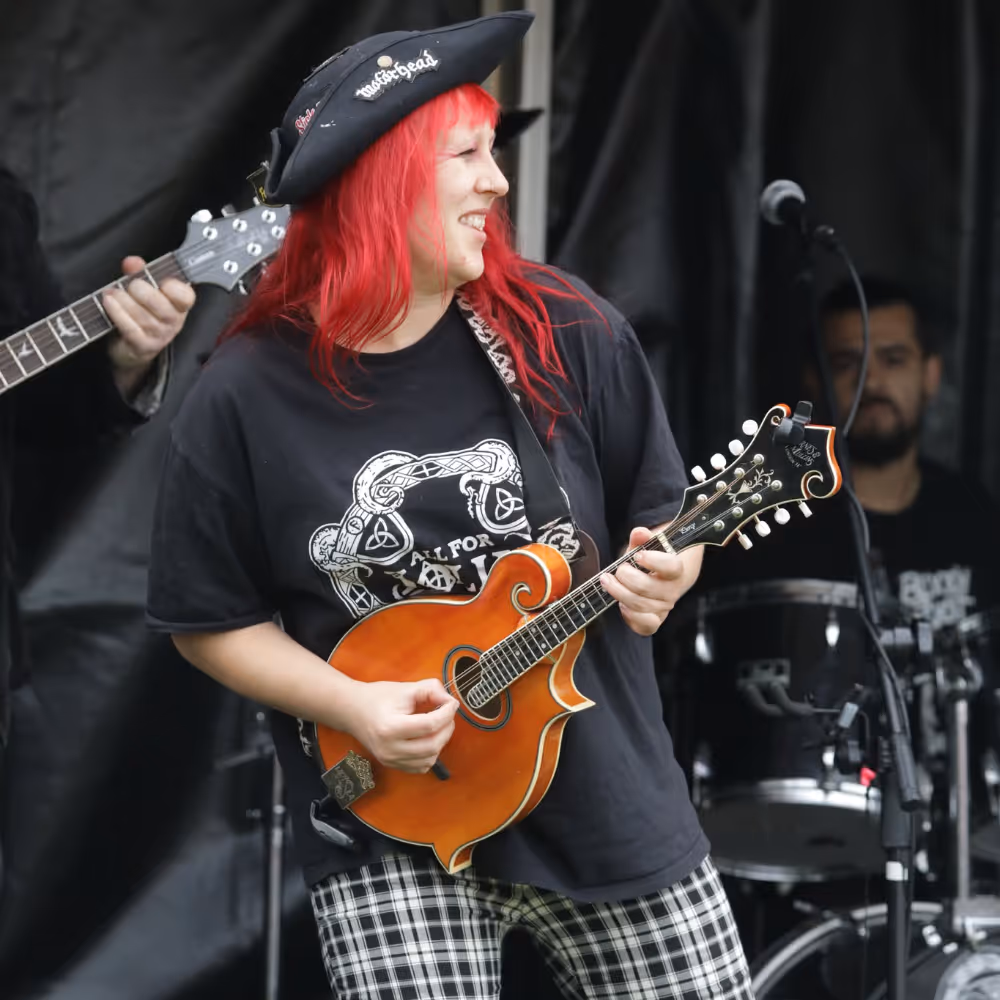 A lady in pirate costume playing an instrument on a stay.
