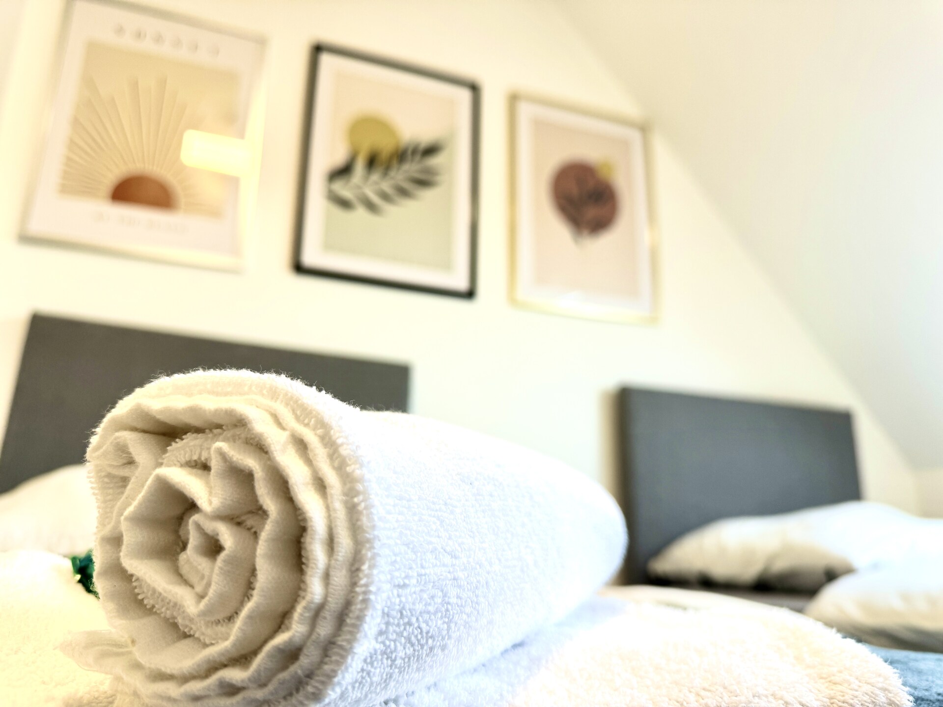 Gerolltes Handtuch auf Bett im Gästezimmer