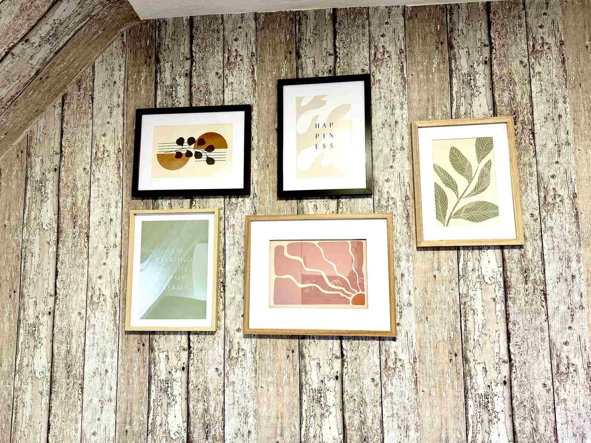 Galeriewand mit Naturmotiven und Sprüchen