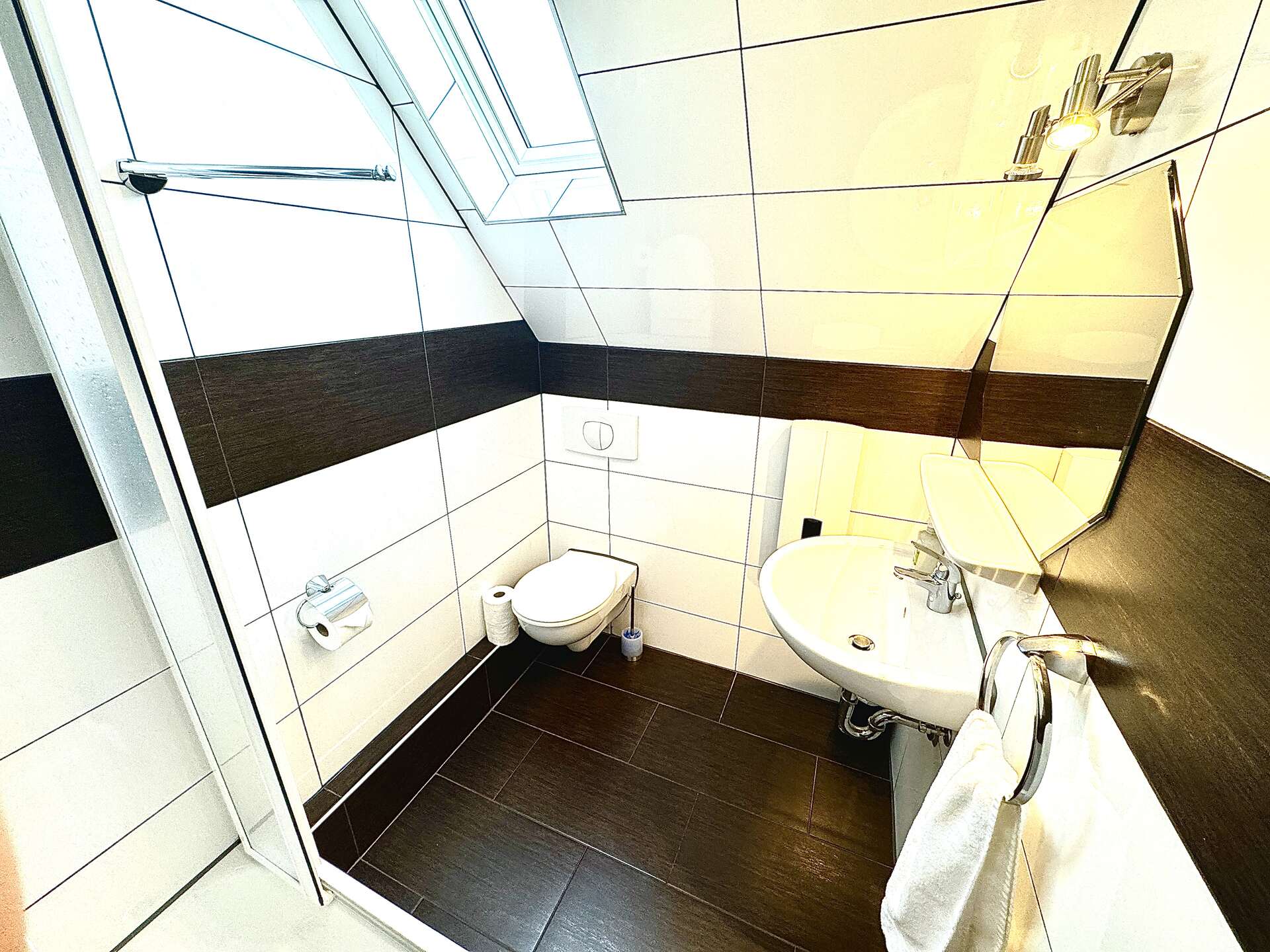 Badezimmer mit Dachfenster und Hängelampe