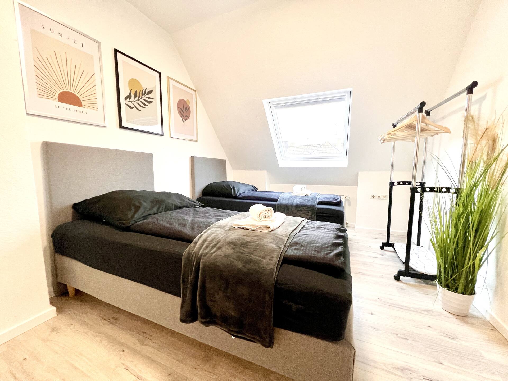 Zweibettzimmer mit Pflanze und hellem Boden