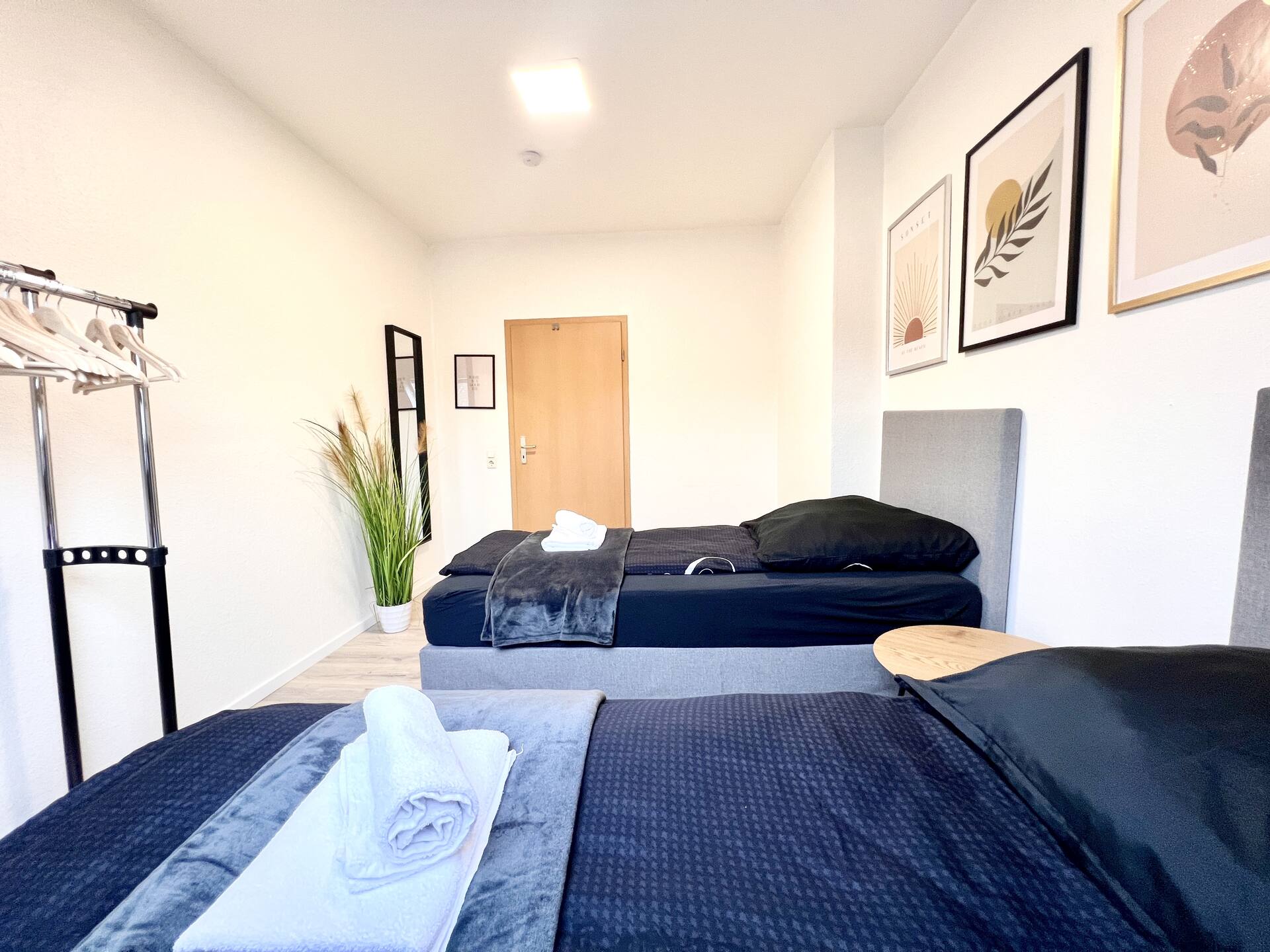 Schlafzimmer mit Spiegel, Pflanzen und Wandbildern
