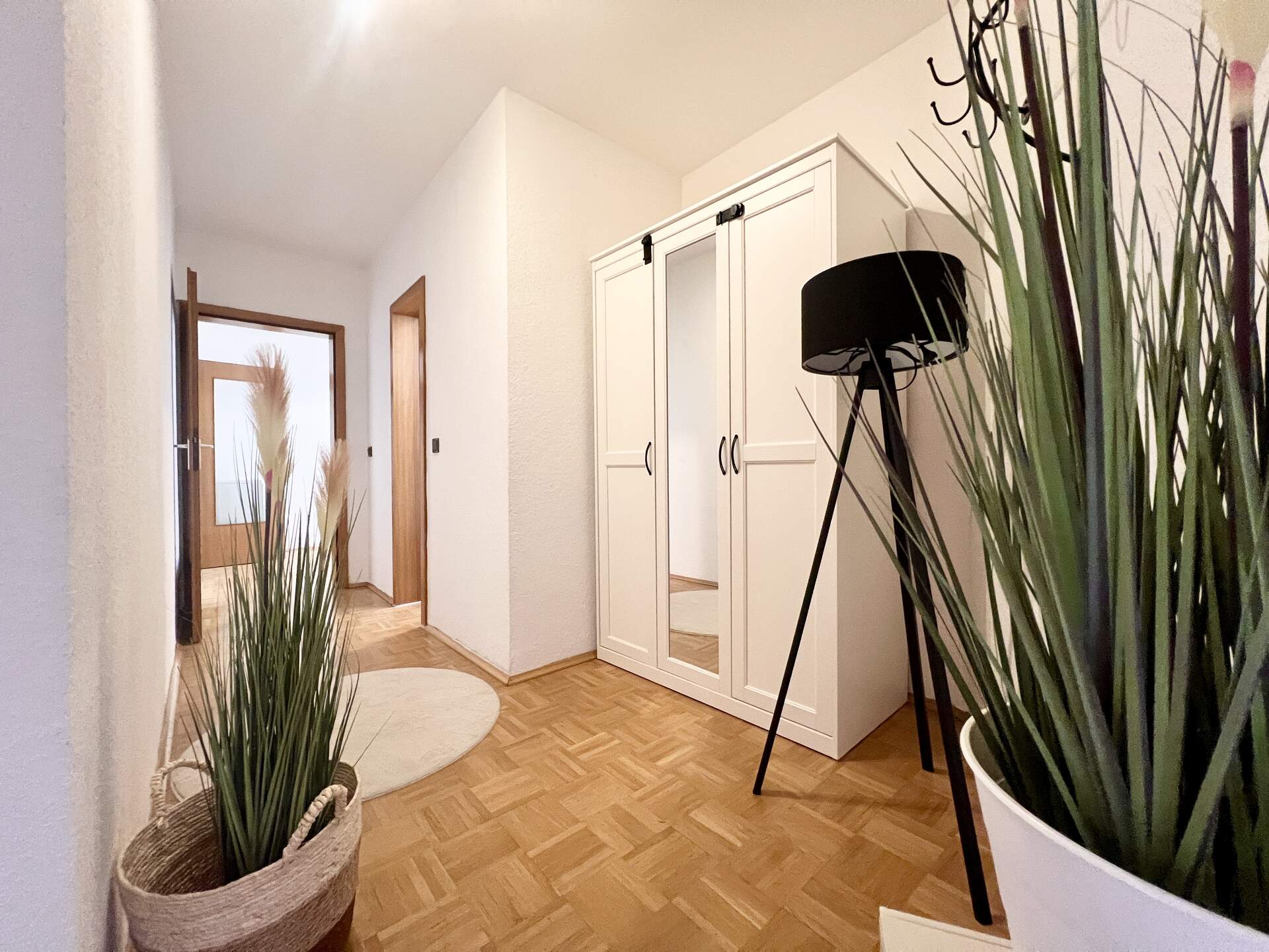Flur mit weißem Spiegelschrank und Dekopflanzen