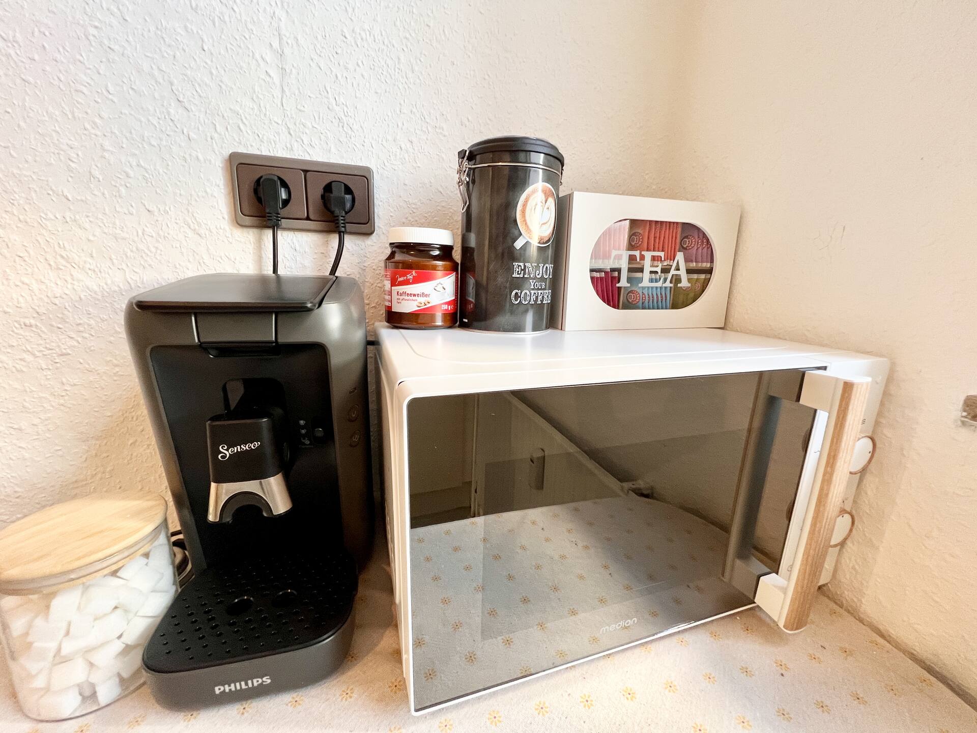 Kaffeemaschine, Mikrowelle und Vorräte in der Küche