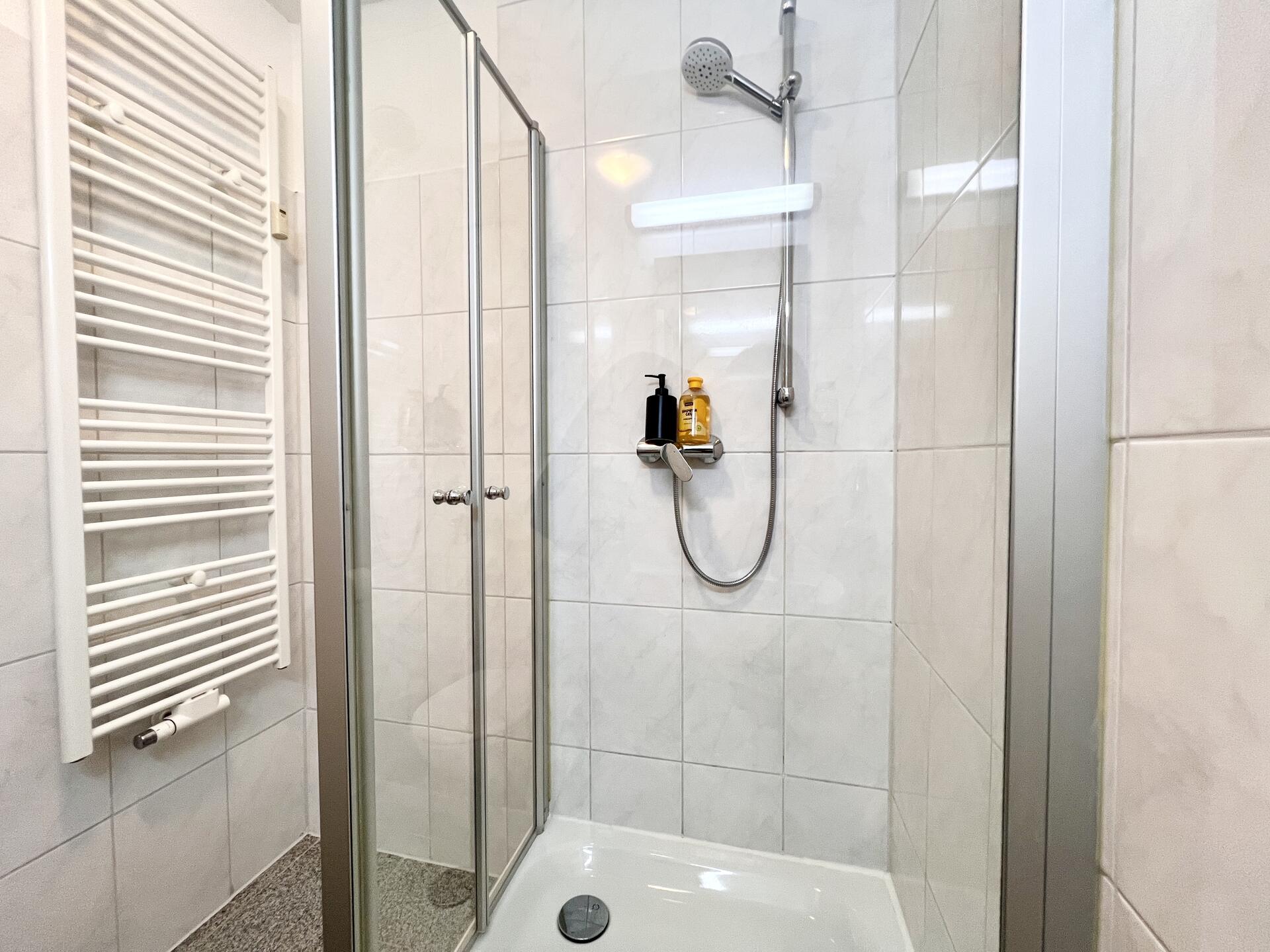 Dusche mit Glaswand und schwarzem Spenderset