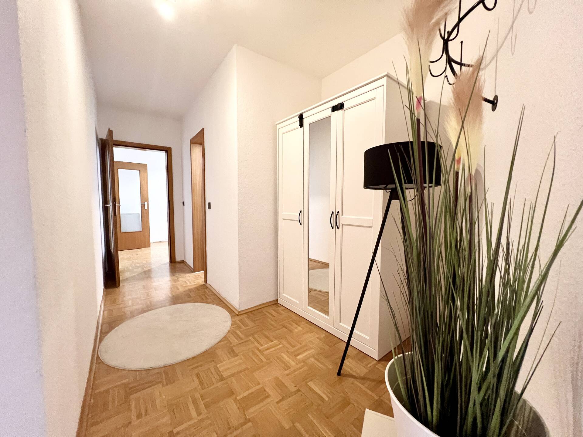 Flur mit schwarzer Stehlampe und Spiegelschrank