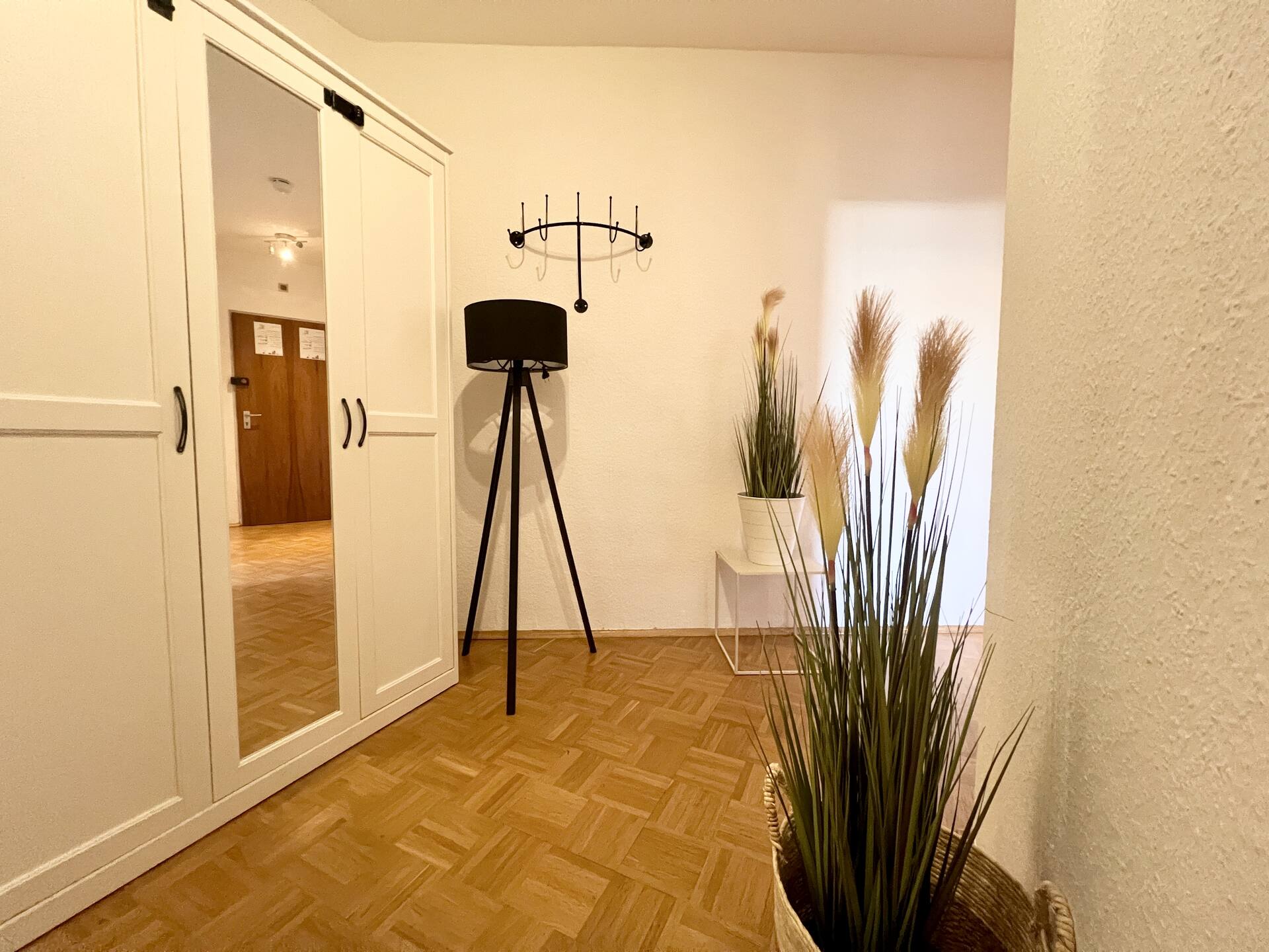 Flur mit weißem Spiegelschrank und Dekopflanzen