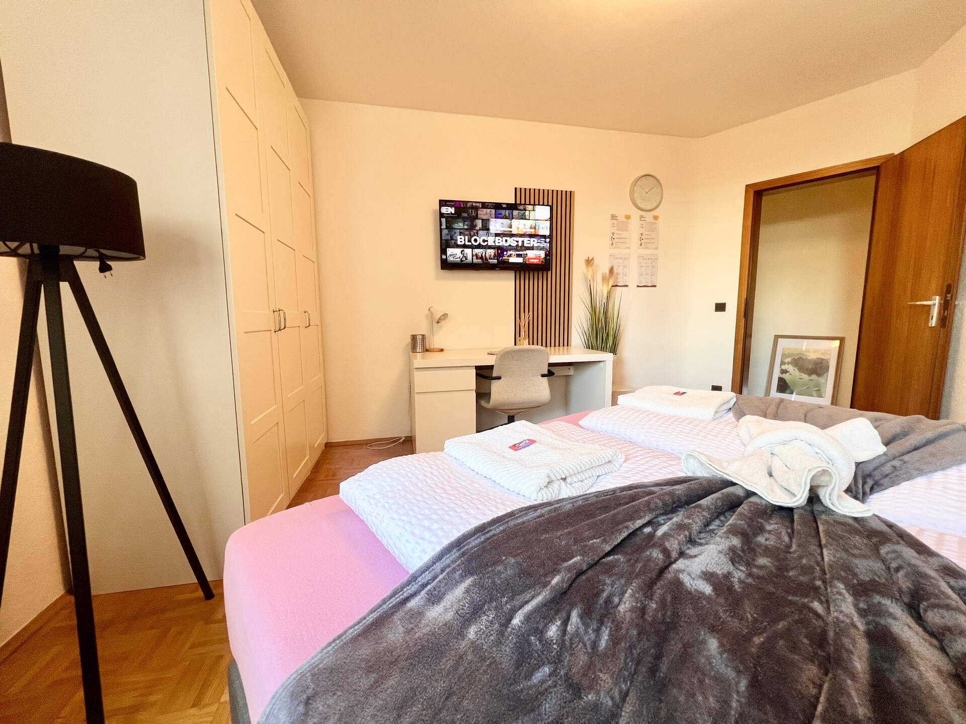 TV über Schreibtisch mit hellem Drehstuhl
