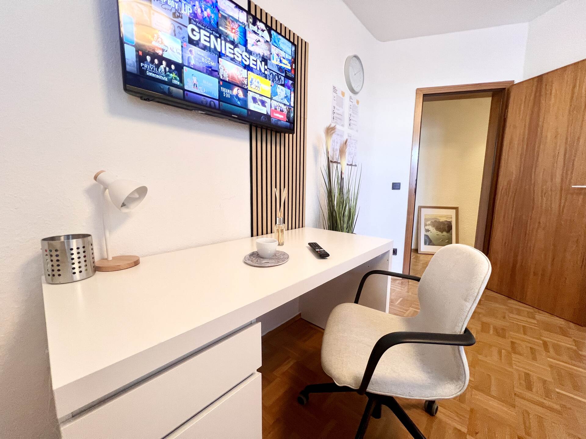 Schreibtisch mit TV und gemütlichem Stuhl