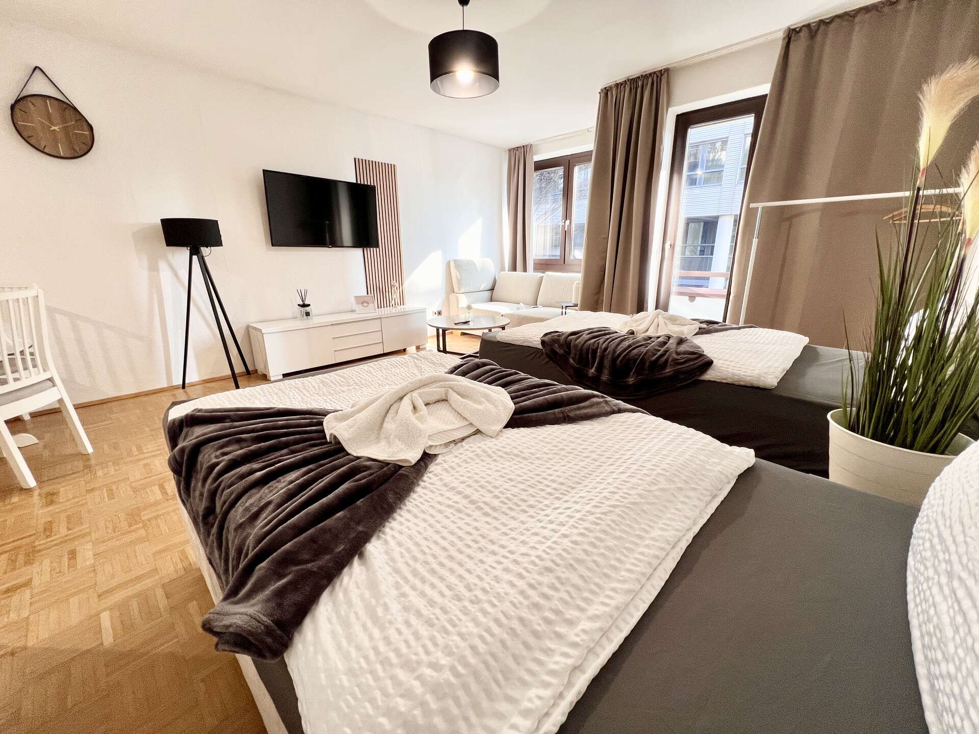 Zwei Betten mit TV und Sofaecke im Hintergrund