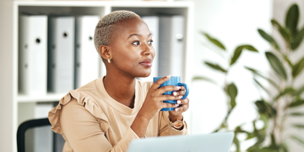 A risk analyst in a modern office taking a moment to think, representing the clarity gained by moving from data overload to early-warning risk intelligence.