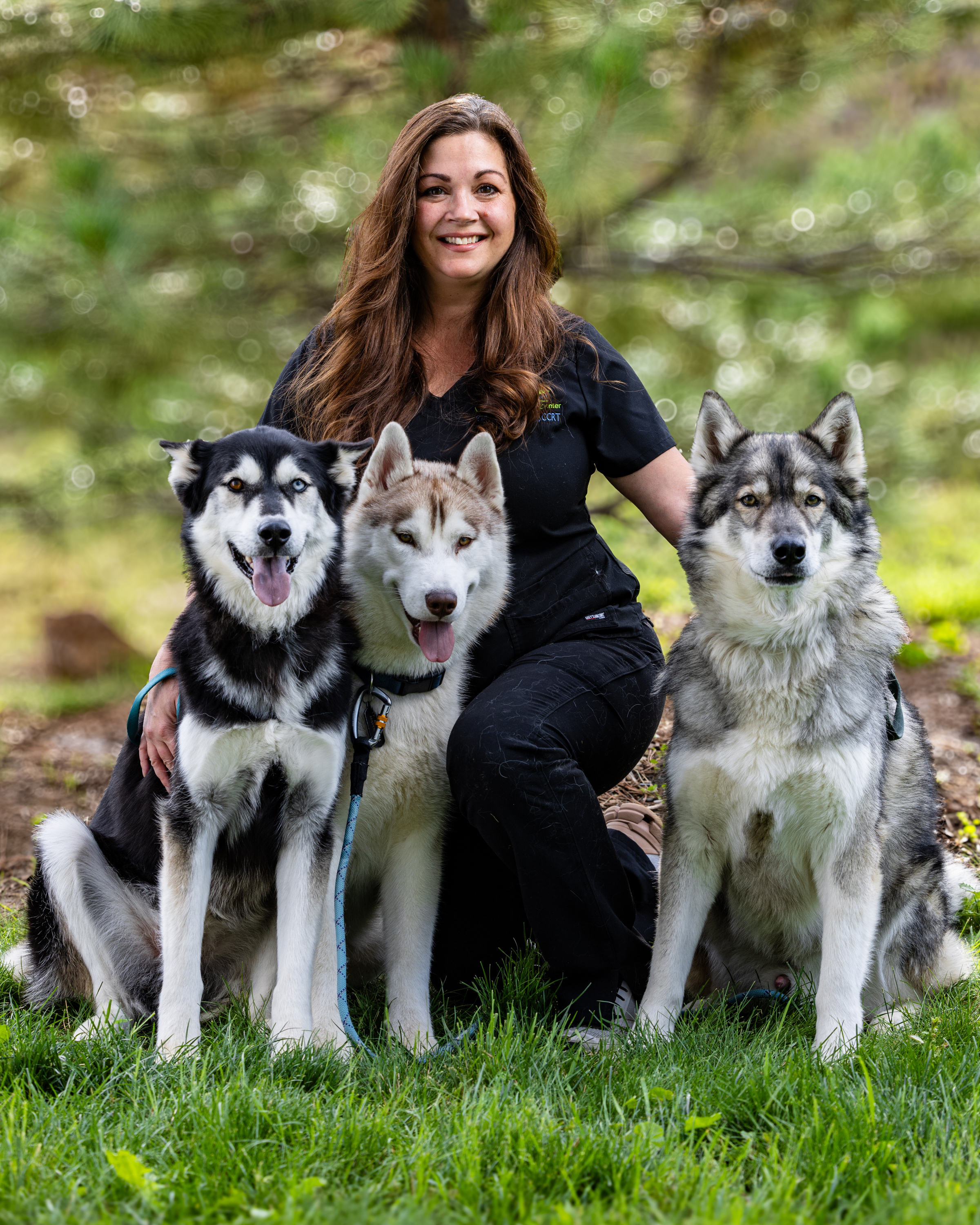Kelly Hansen kneeling next to her 2 beautiful and healthy Huskies.