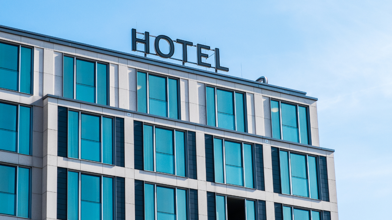 a building with several glass windows with an inscription of HOTEL on top of the roof 