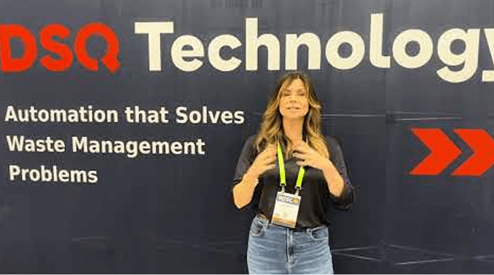 a lady on black shirt and blue Jean in front of DSQ Technology banner