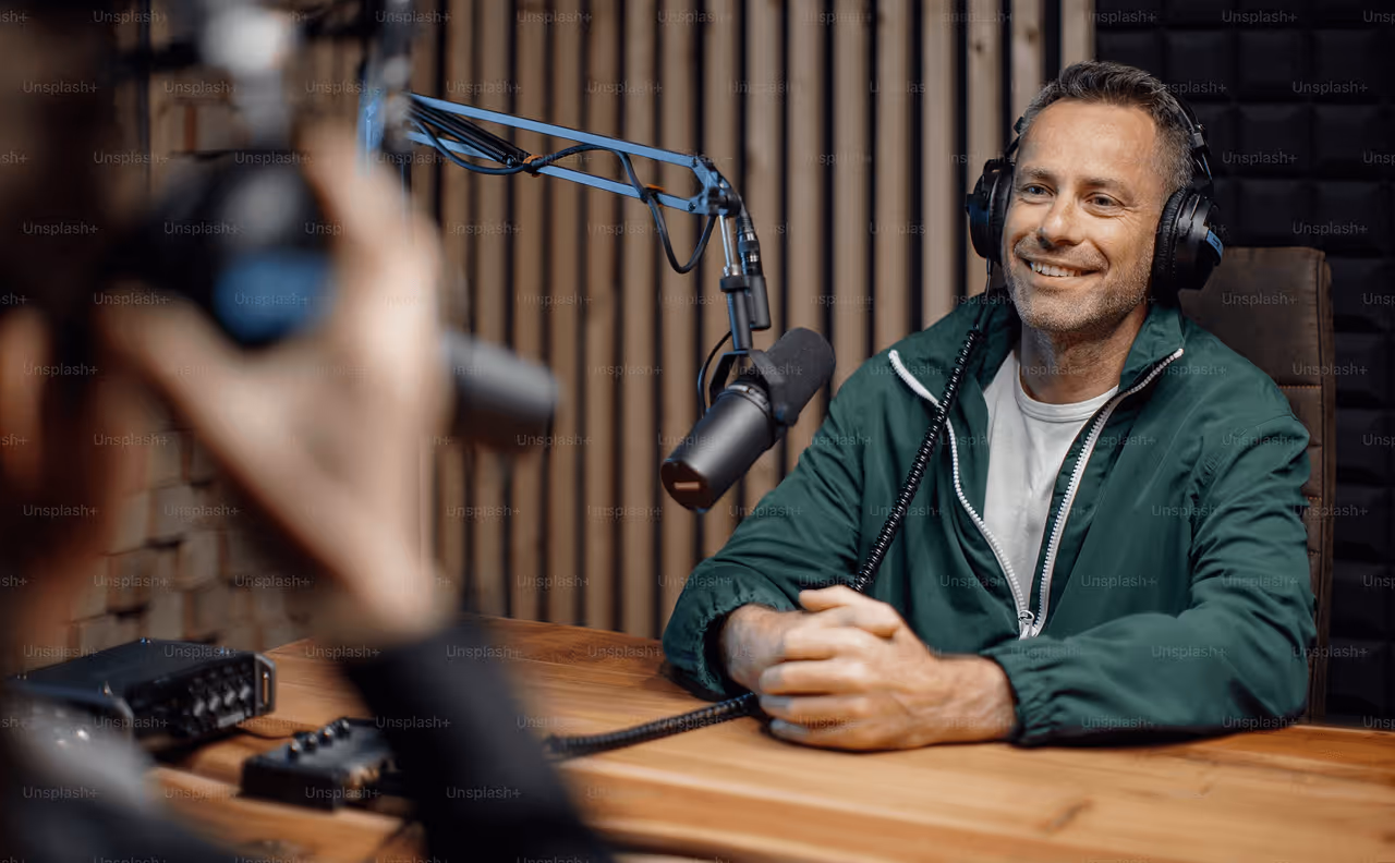 aman on green shirts talking with a podcast mic