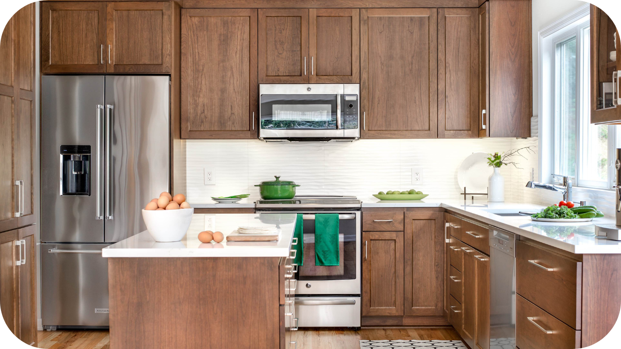 A modern U-shaped kitchen with medium-brown wood cabinets, stainless steel appliances, and a white tiled backsplash.