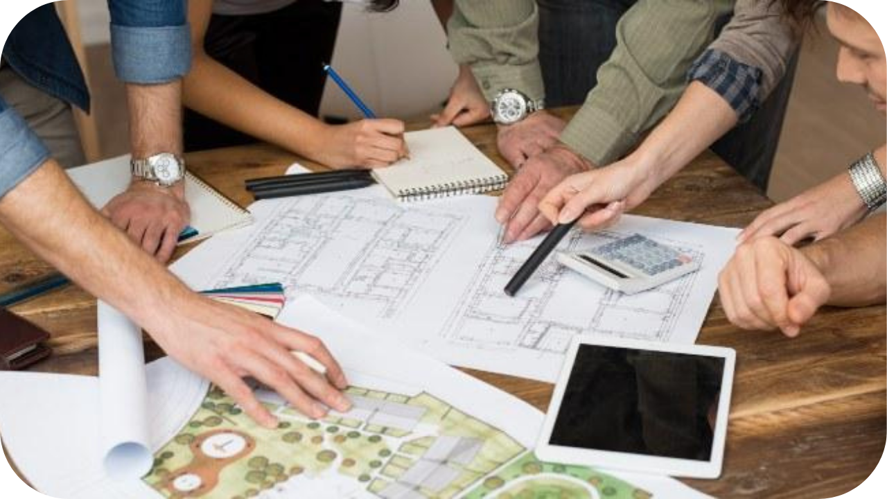 Team of architects collaborating on home design blueprints, using sketches, calculators, and digital tools for project planning.