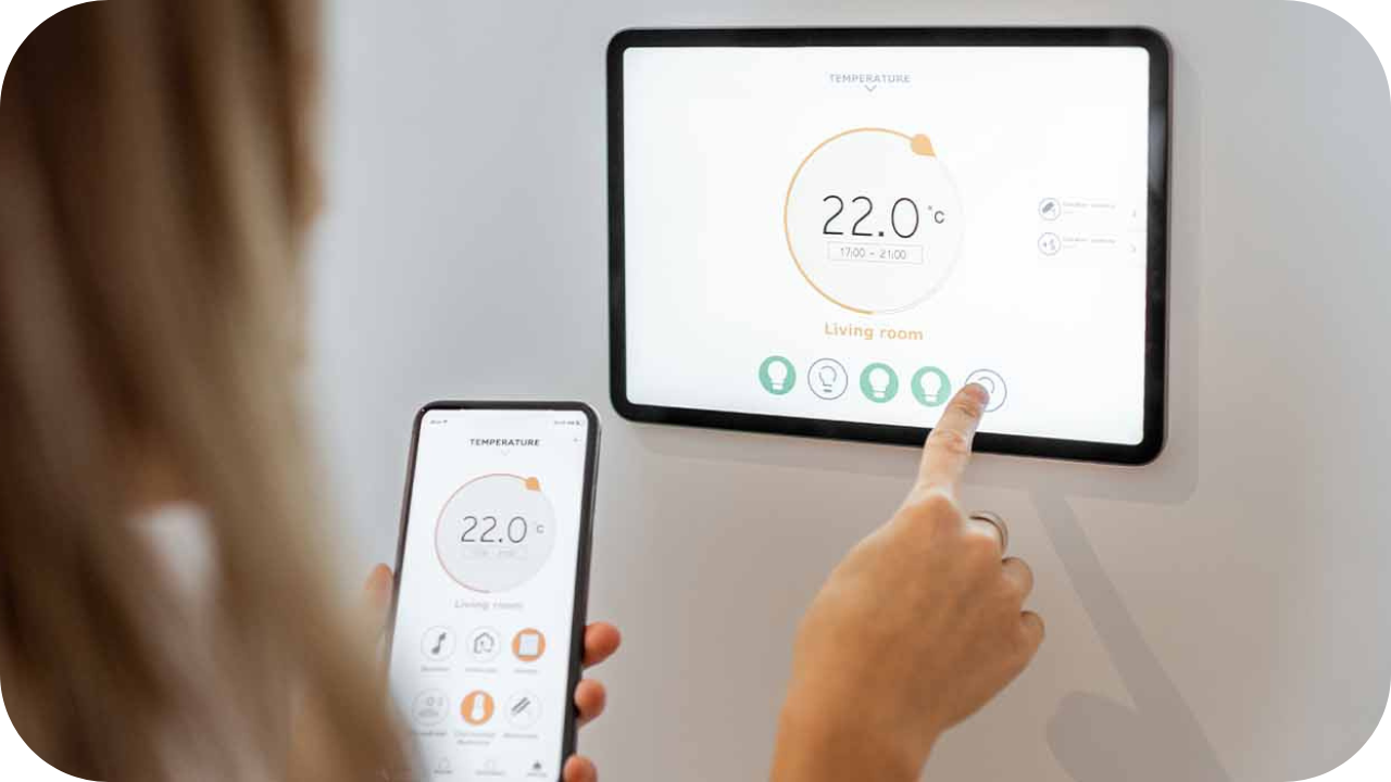 A smart home system showing climate control on both a wall-mounted screen and a smartphone, displaying a set temperature of 22°C in the living room.