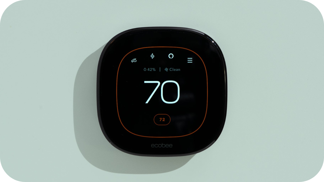 A modern smart thermostat mounted on a wall, displaying a temperature of 70 degrees, designed for energy-efficient home climate control.