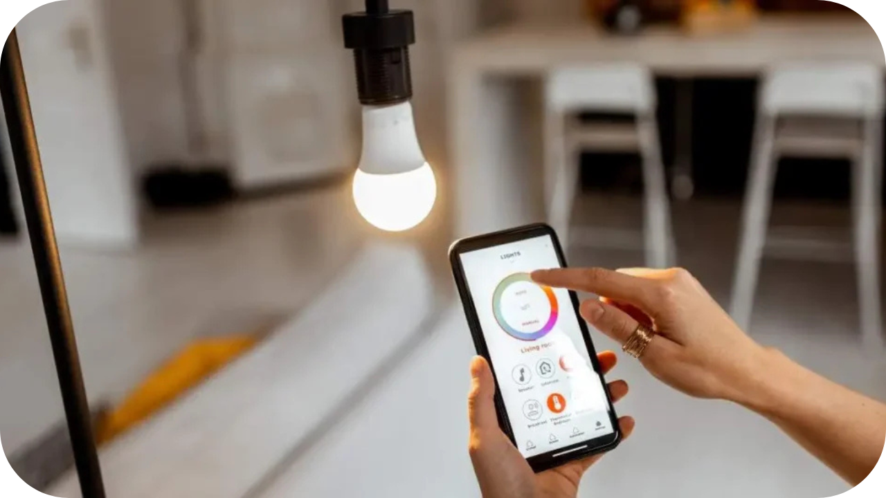 A person using a smartphone app to control a smart light bulb, adjusting brightness and colour settings in a modern home environment.