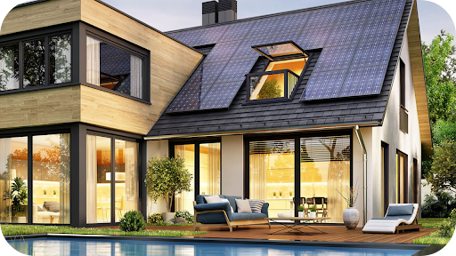 Modern house with large solar panels on the roof, glass windows, outdoor seating, and a poolside deck surrounded by greenery.