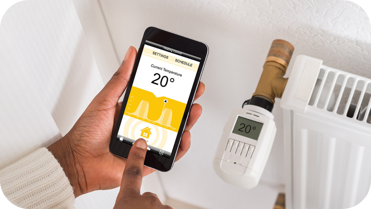 A person adjusting a smart thermostat using a mobile app, with the screen showing a temperature setting of 20°C next to a radiator.