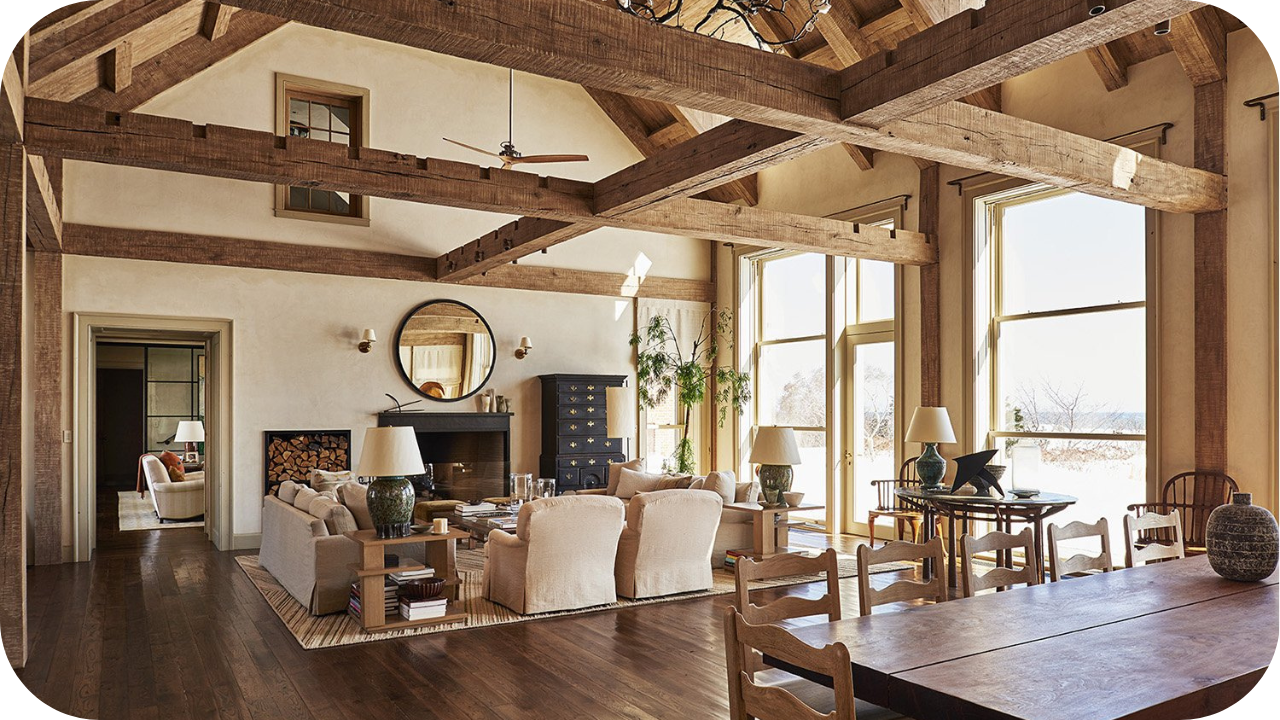 Rustic farmhouse living room with exposed wooden beams, natural light, and cosy seating, styled for timeless design charm.