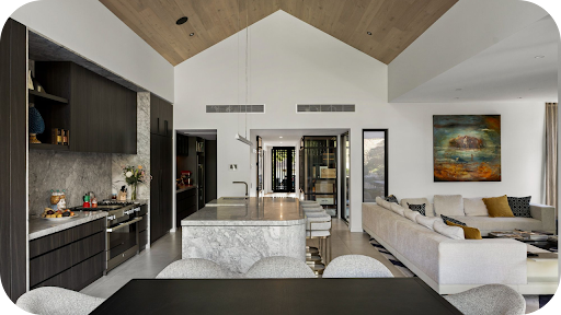 Luxury open-plan interior featuring a marble kitchen island, timber finishes, modern cabinetry, and a stylish living room with artwork.