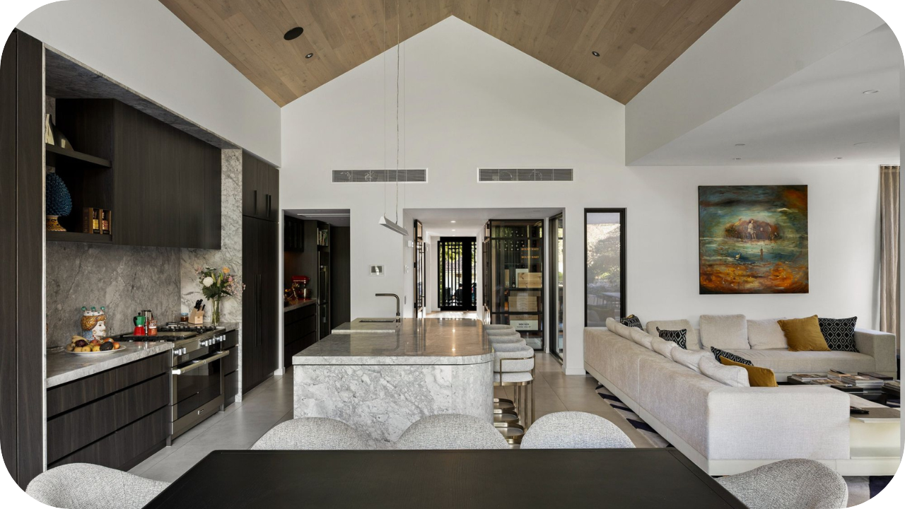 Stylish entertainment space with backlit bar, stone walls, wooden flooring, and pool table under pendant lighting.