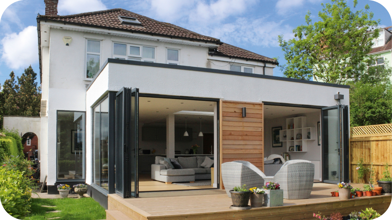 A bright rear home extension in Melbourne with bi-fold glass doors opening to a timber deck, connecting the indoor lounge to outdoor entertaining space.