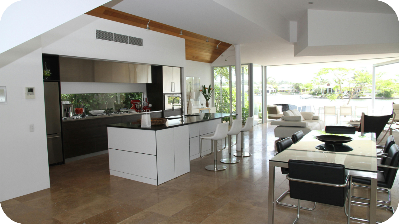 Open-plan modern kitchen and dining area with large glass doors leading to an outdoor living space in a Melbourne home.