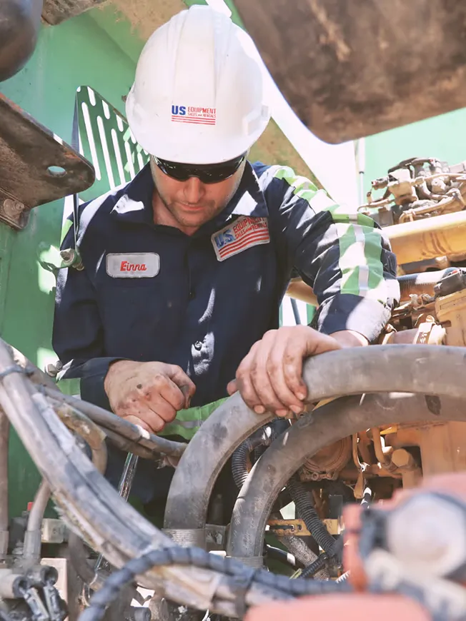 A man in a hard hat working on a piece of machinery.