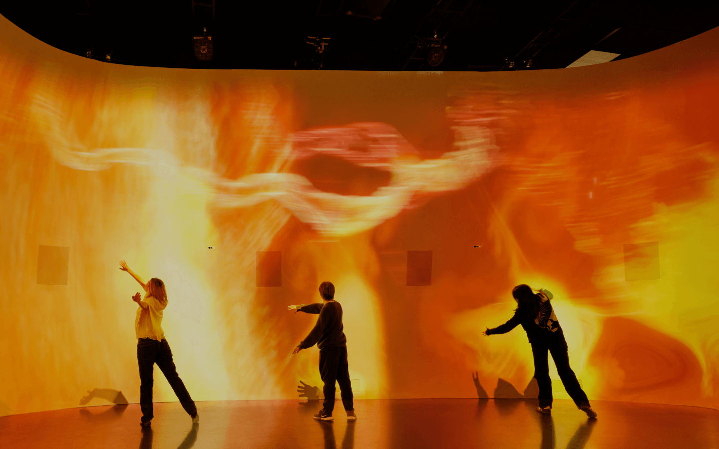 Group activity showing 3 people swooshign in front of an orange light wall