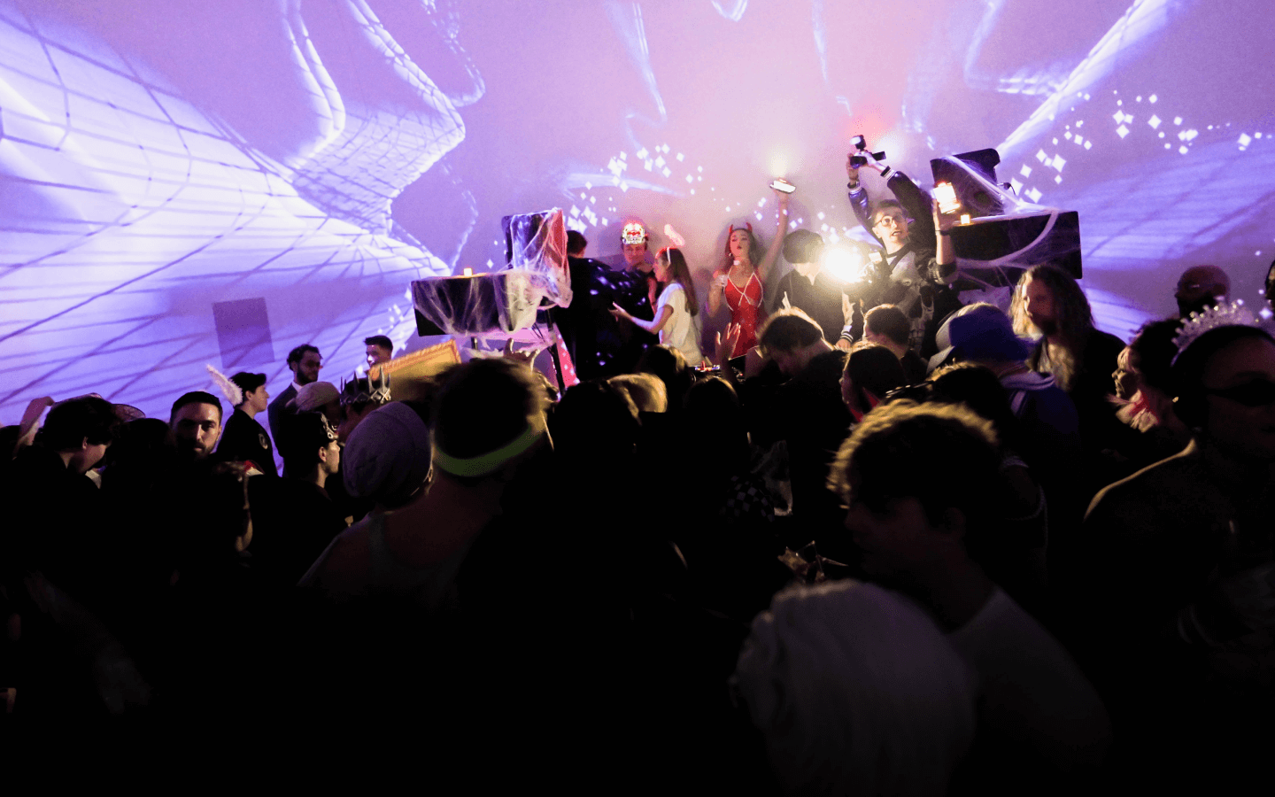 Private party venue in NYC - INTER's exclusive room hire showing a group of people celebrating and dancing with a DJ and halloween costumes