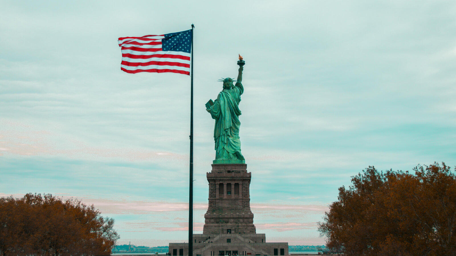 Statue of Liberty against a backdrop of fall colored trees
