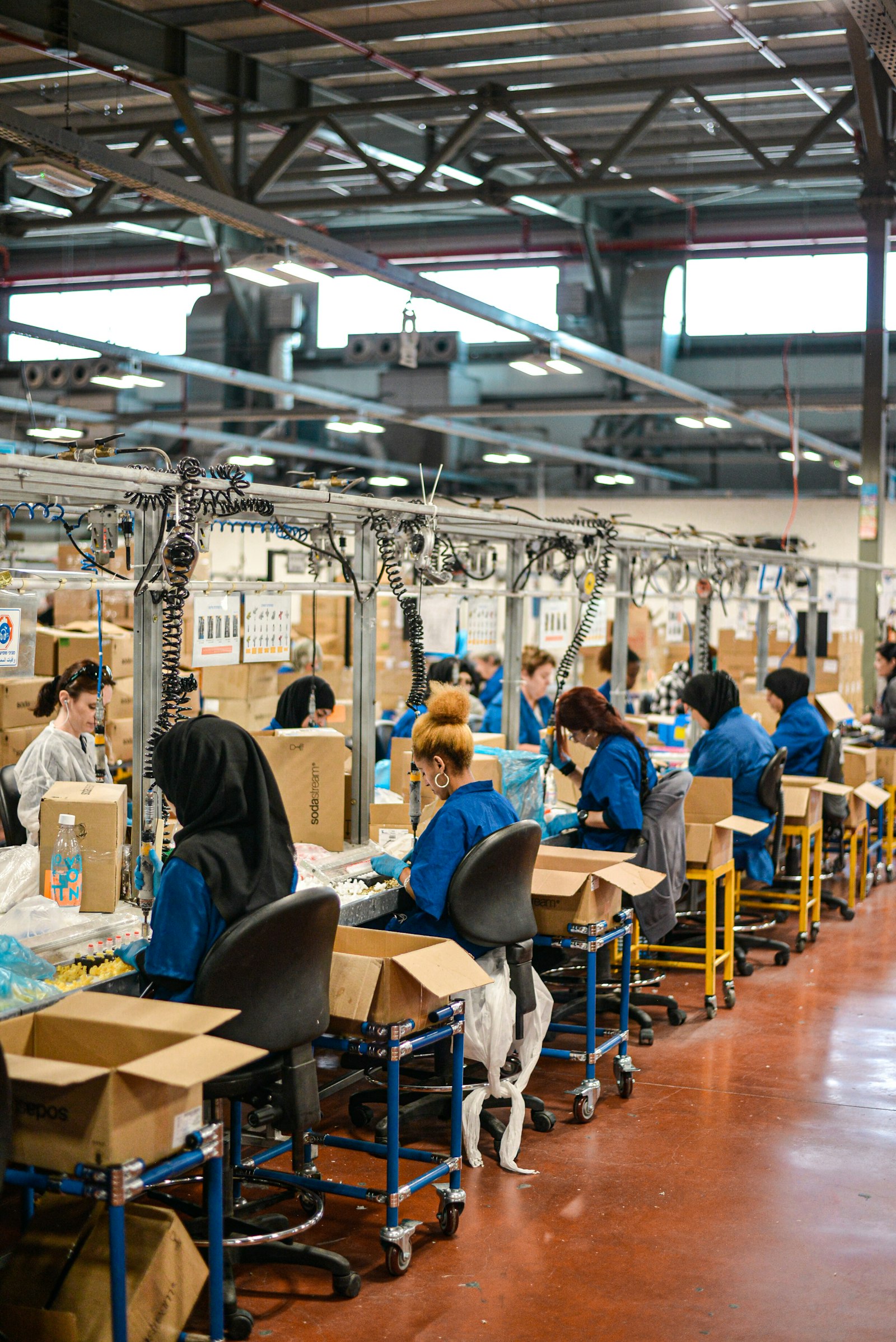 Workers in blue uniforms on a factory assembly line