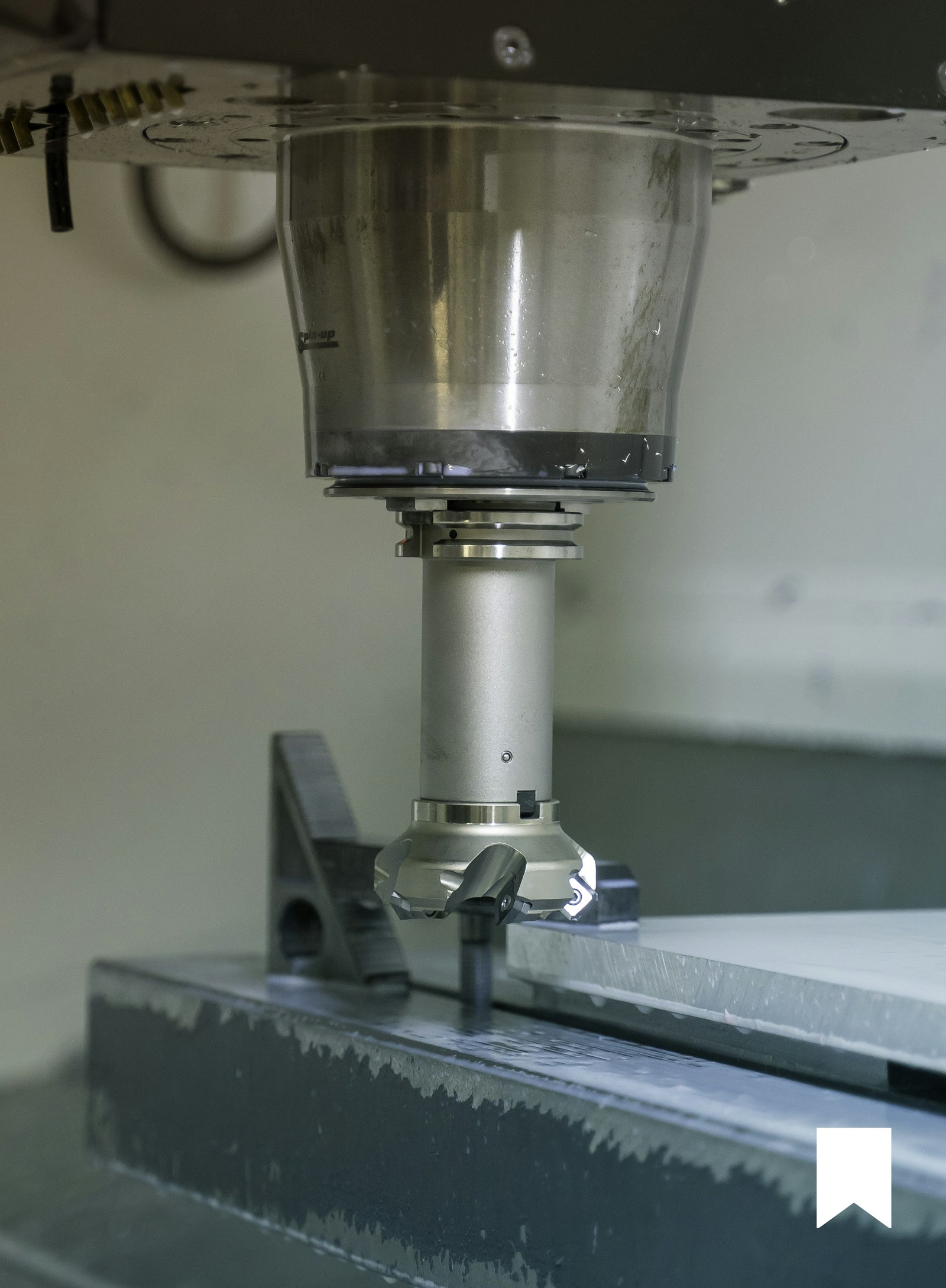 A manufacturing apprentice working with an industrial machine tool under mentorship