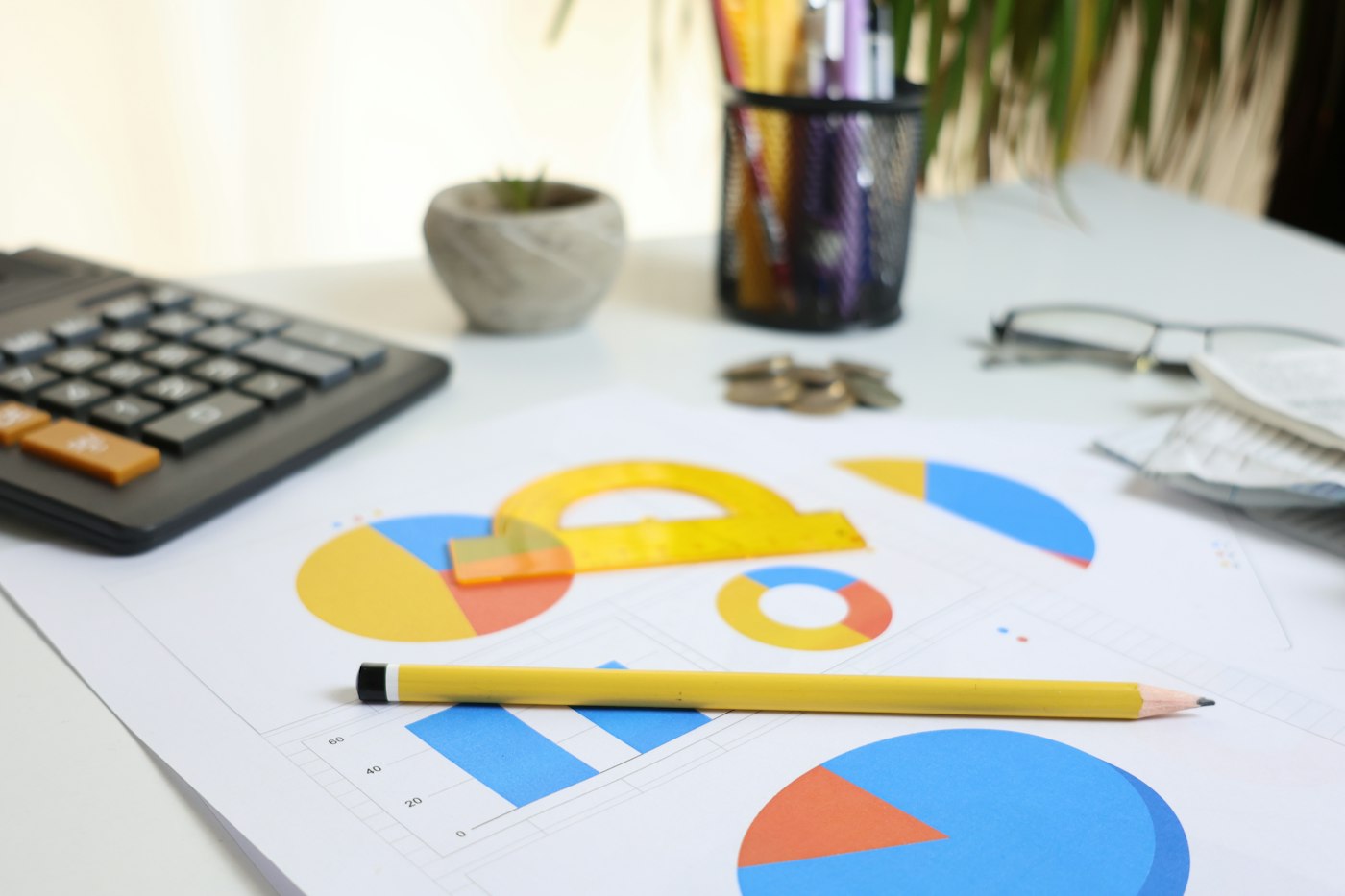 Calculator and financial charts on a desk for comparing salary offers
