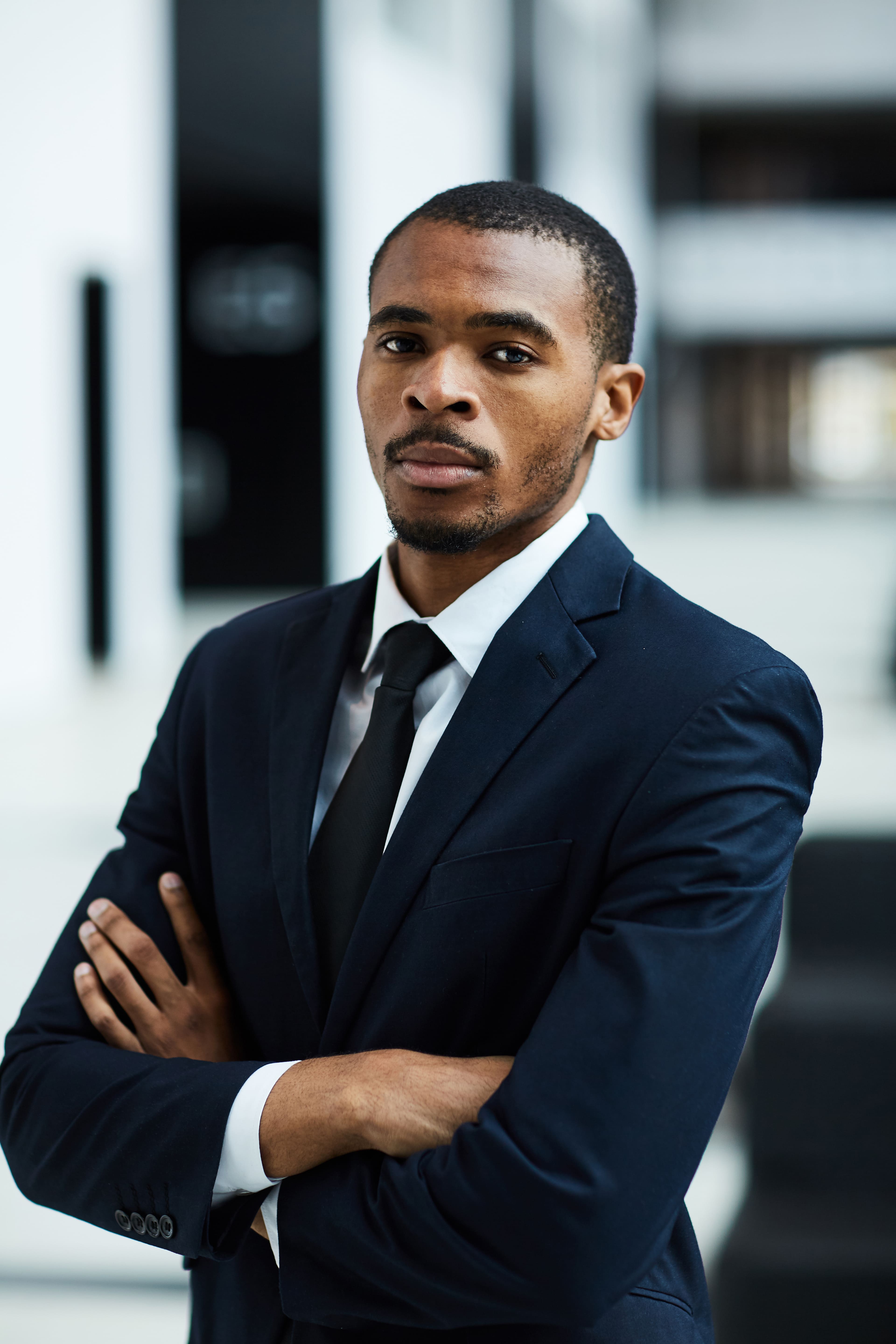 A man in a suit and tie with his arms crossed.