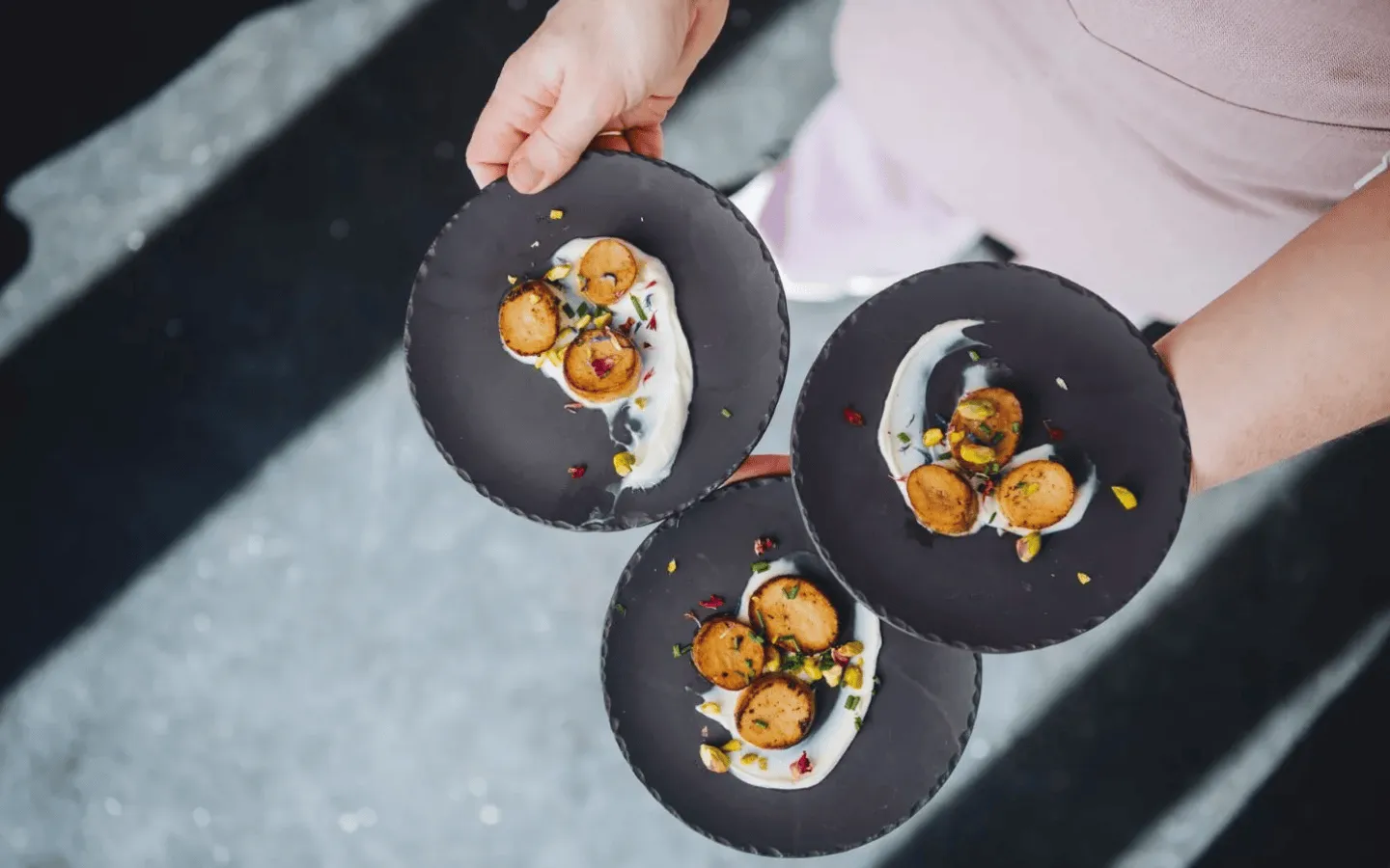 Drie donkere borden met eten die vastgehouden worden
