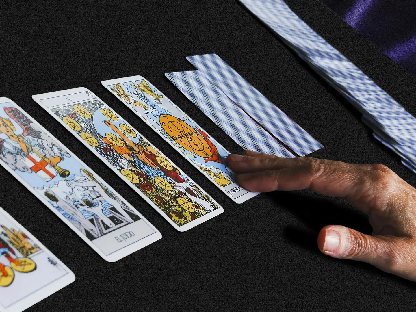 een rij tarot kaarten met een hand die een kaart omdraait