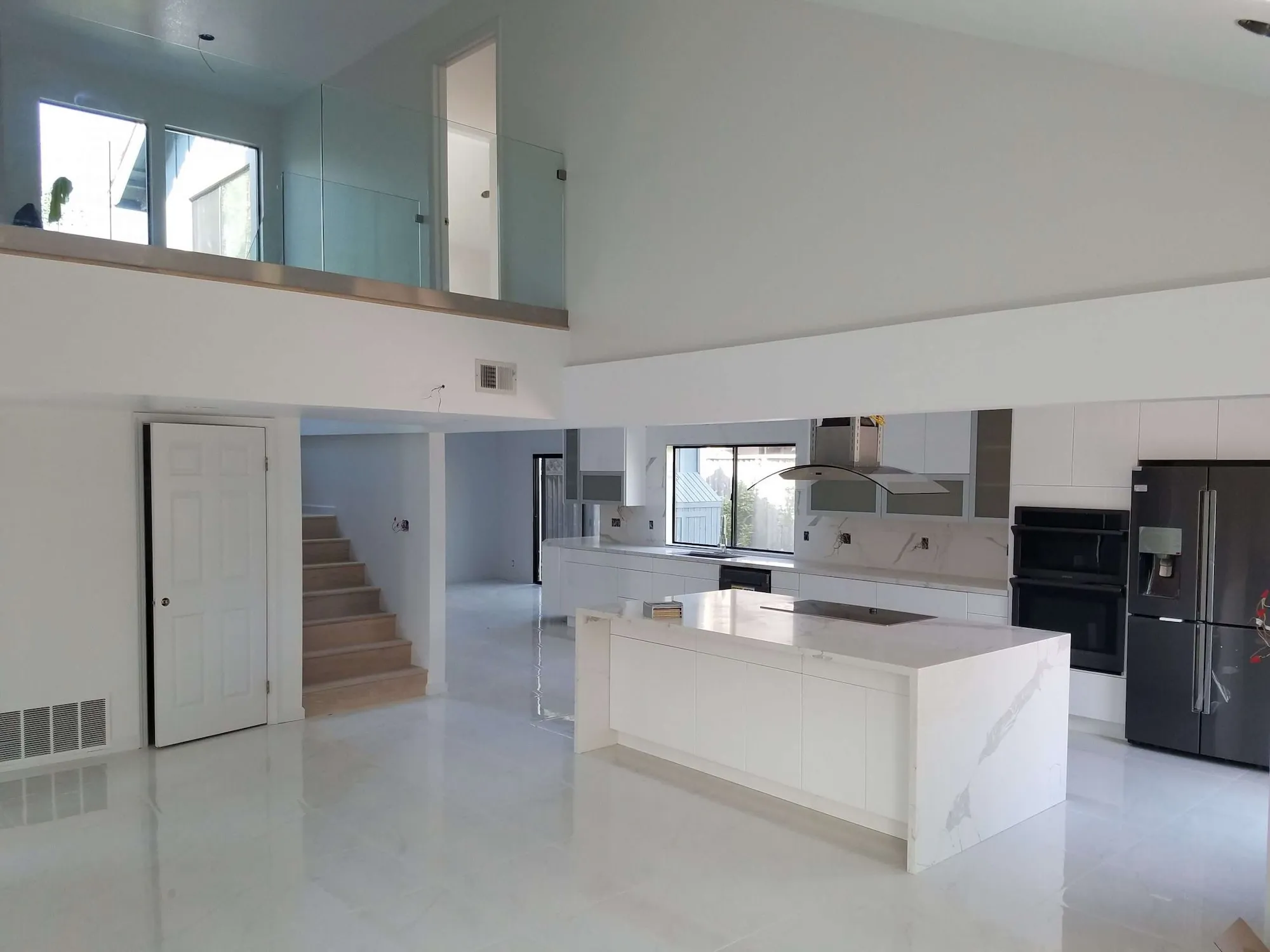 Modern kitchen with vaulted ceiling, wood beams, open shelving, and round dining table