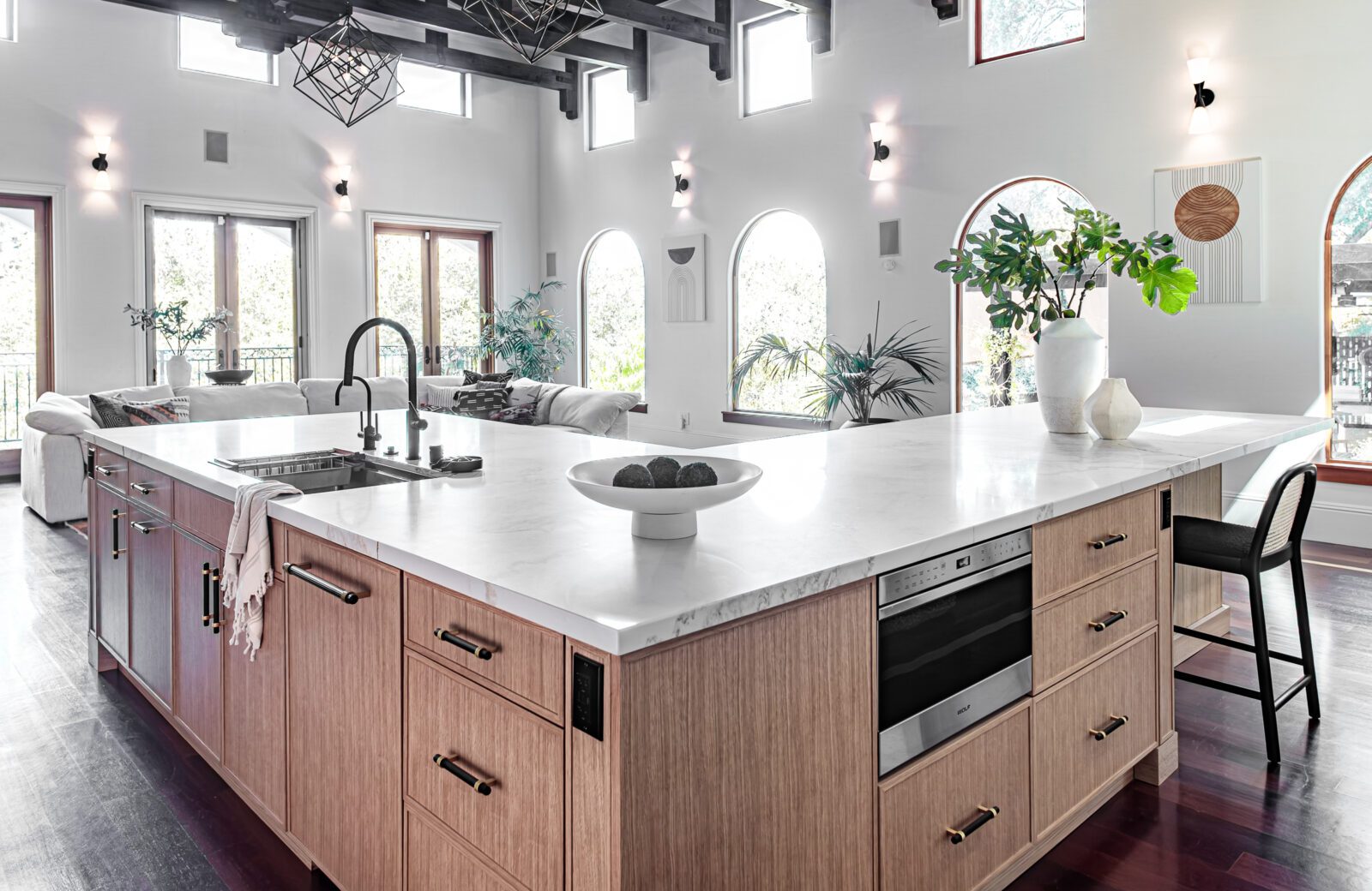 Modern kitchen with vaulted ceiling, wood beams, open shelving, and round dining table