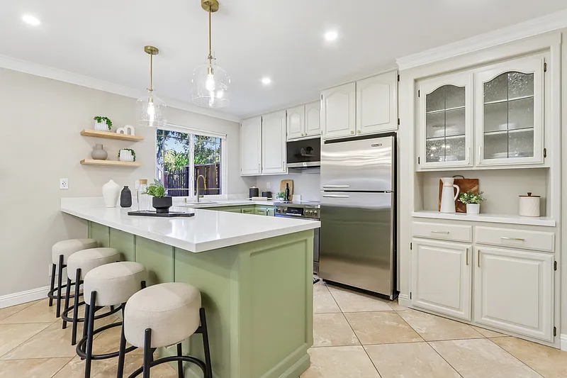 Modern kitchen with vaulted ceiling, wood beams, open shelving, and round dining table