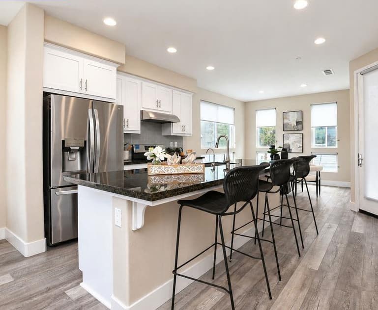 Modern kitchen with vaulted ceiling, wood beams, open shelving, and round dining table