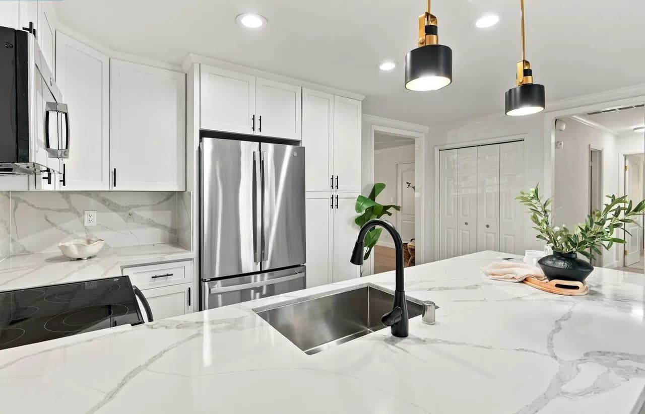 Modern kitchen with vaulted ceiling, wood beams, open shelving, and round dining table