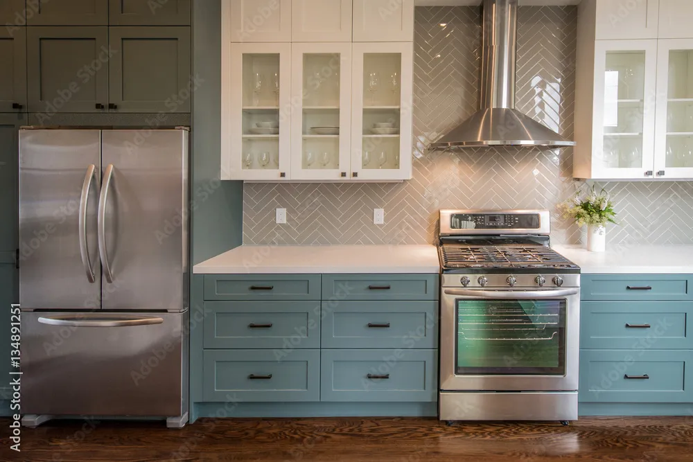  Modern kitchen with shaker cabinets, stainless steel appliances, subway tile backsplash, and range hood