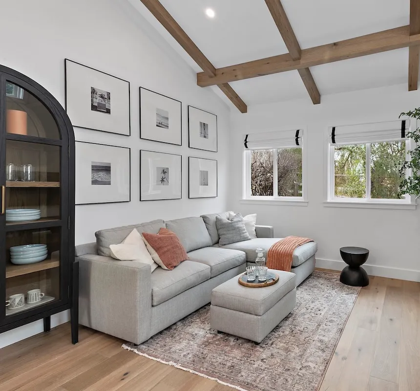 Empty living room space with light-colored hardwood flooring before renovation