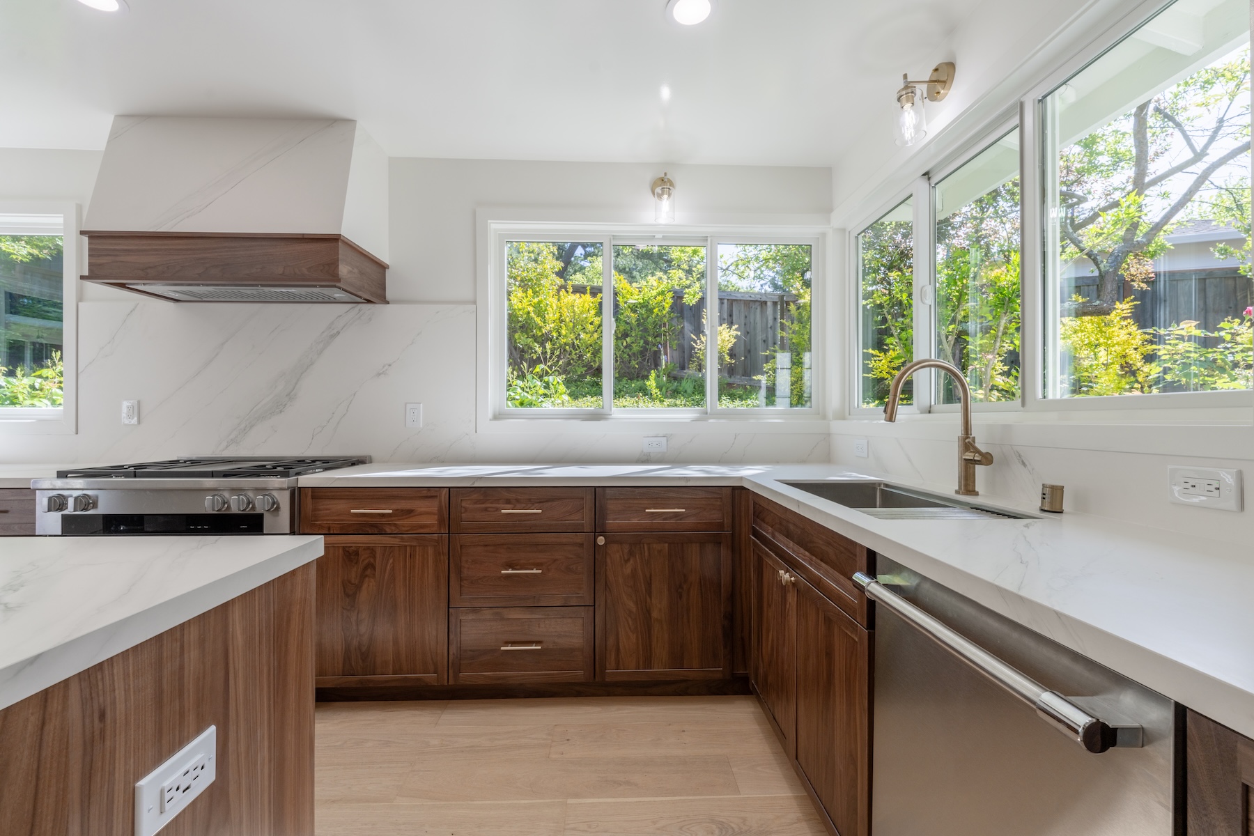 Kitchen remodel by LRL Builders in Orinda with walnut cabinets, white stone counters, and garden windows