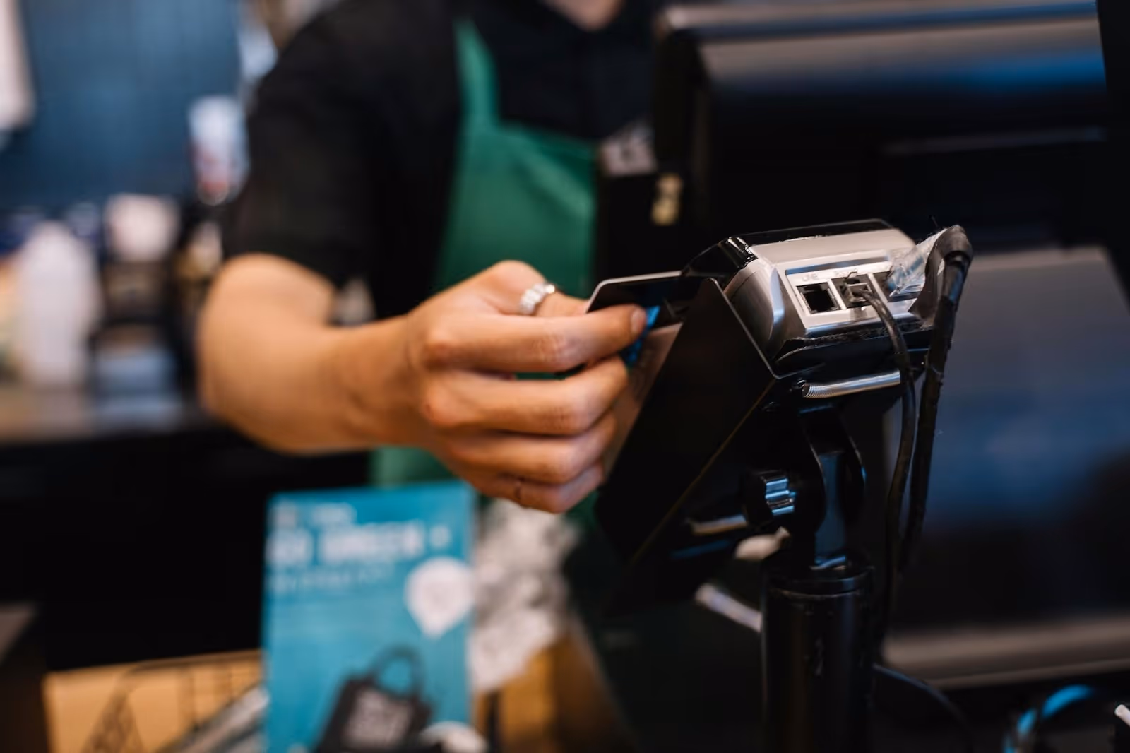 A cashier holding a card in front of the card machine